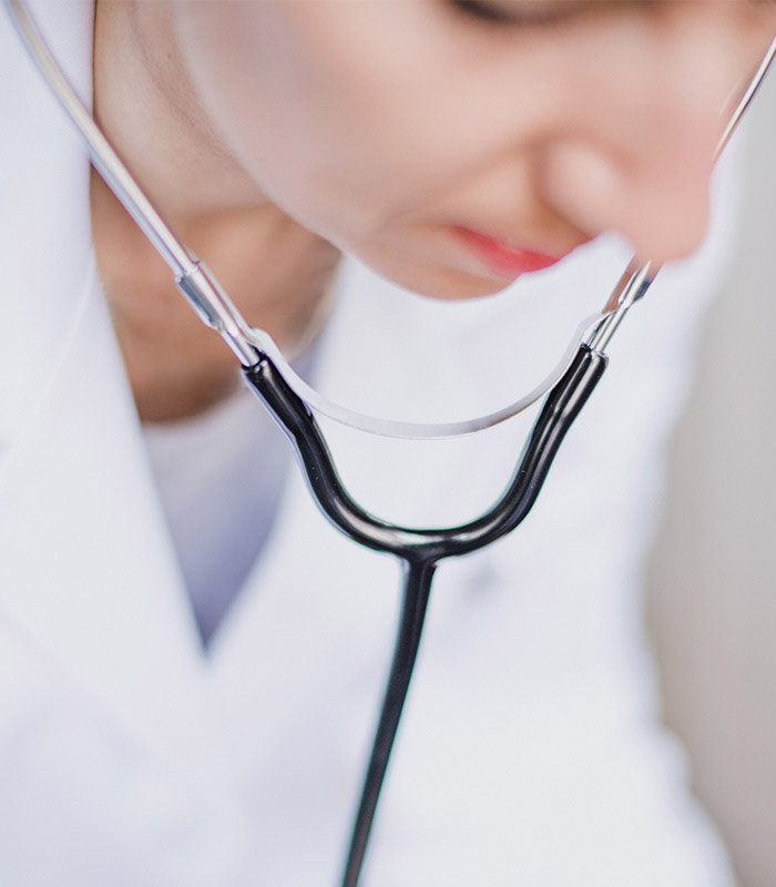 Clinician in a white coat wearing a stethoscope